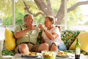 Elderly couple toasting while sitting on couch