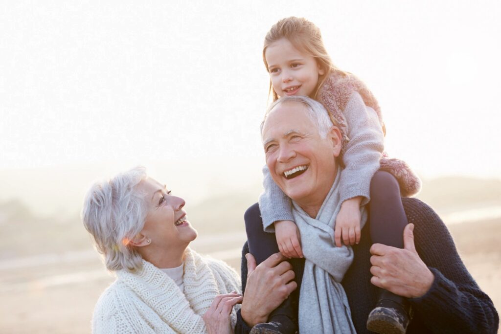 grandparents with grandchild on shoulders